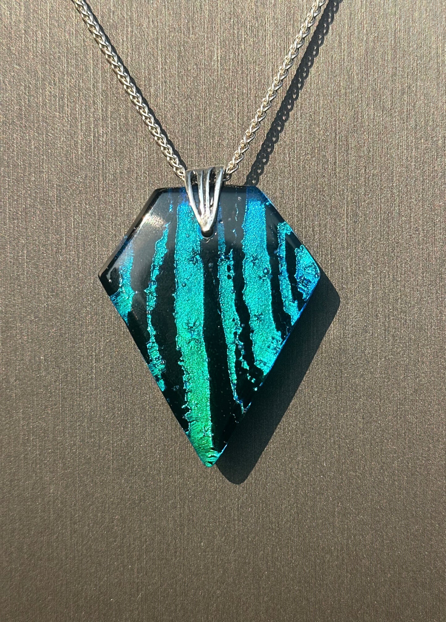 Hand etched and fused blue, teal, green and black multicolor dichroic glass pendant with sterling silver bail and wheat chain.