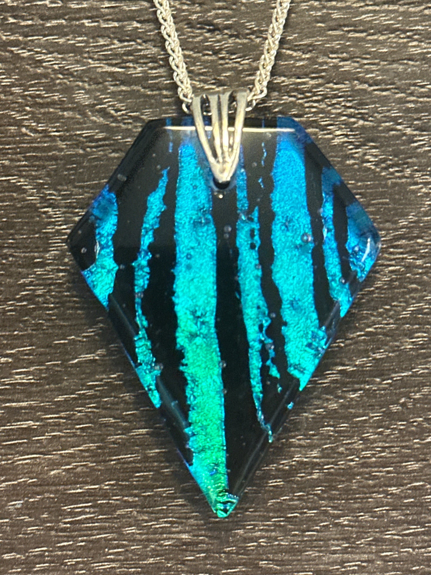 Hand etched and fused blue, teal, green and black multicolor dichroic glass pendant with sterling silver bail and wheat chain.