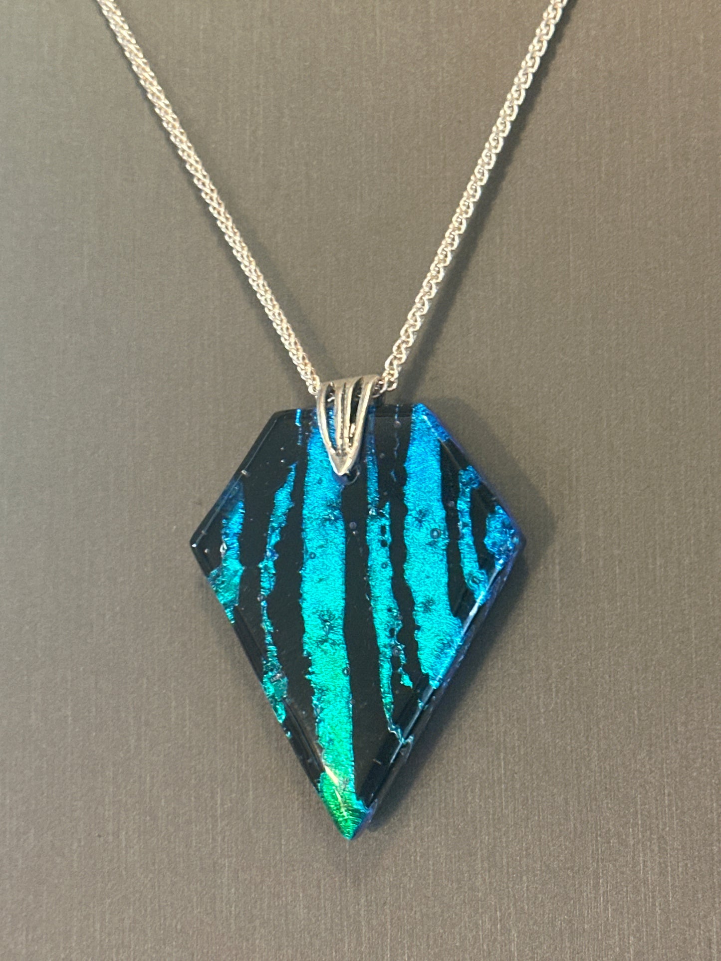 Hand etched and fused blue, teal, green and black multicolor dichroic glass pendant with sterling silver bail and wheat chain.