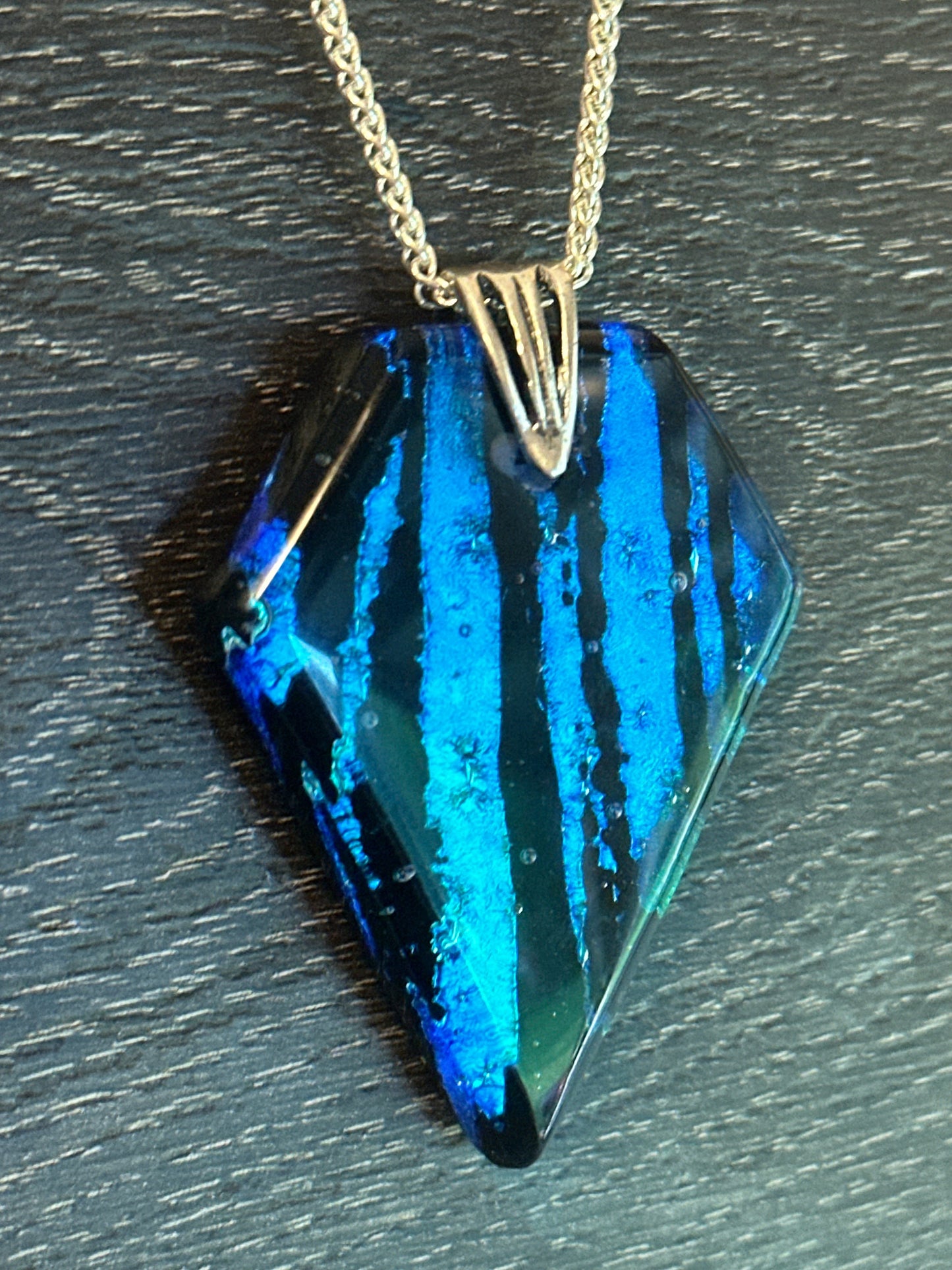 Hand etched and fused blue, teal, green and black multicolor dichroic glass pendant with sterling silver bail and wheat chain.