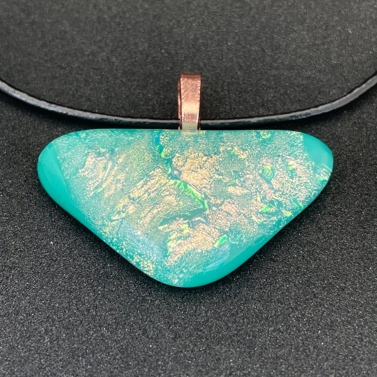 Aqua green and pink dichroic triangular glass pendant with leather cord.