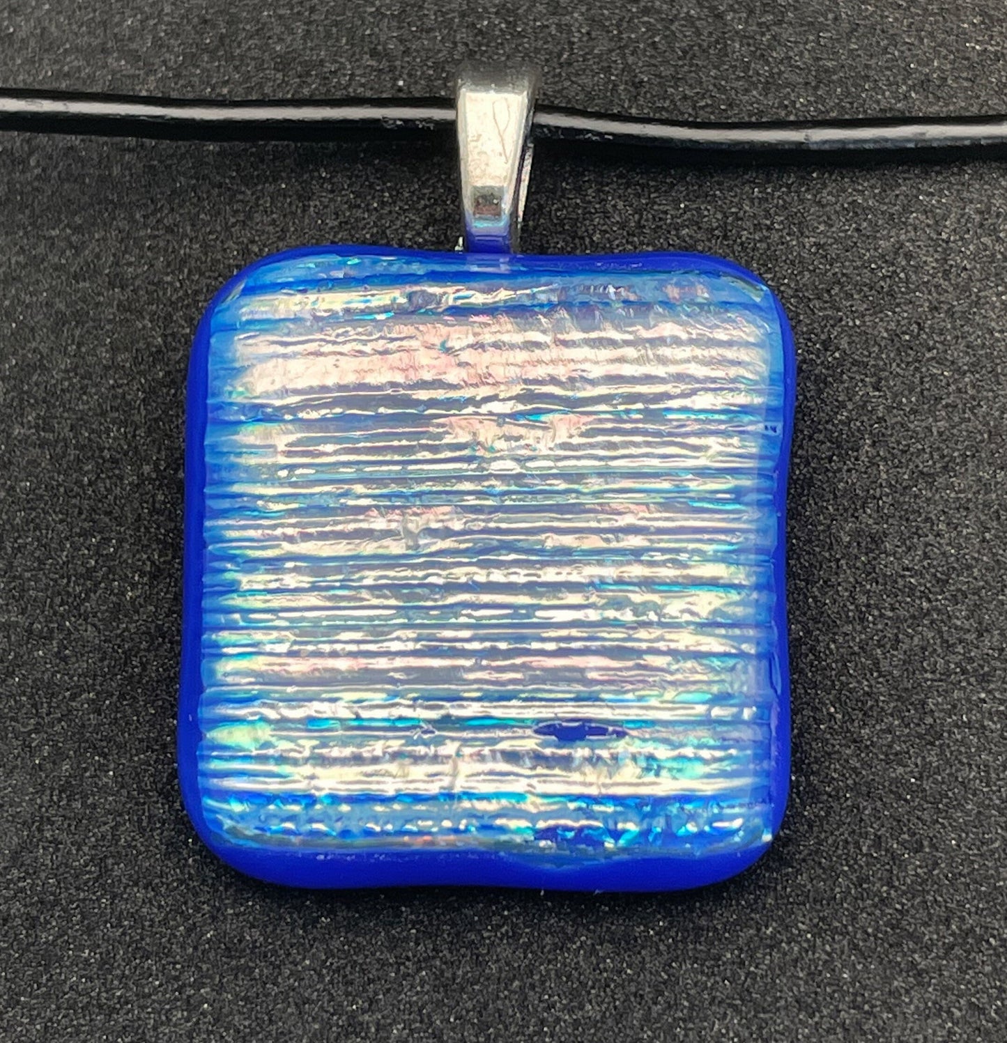 Blue, pink, gold, silver square dichroic glass pendant with leather cord.