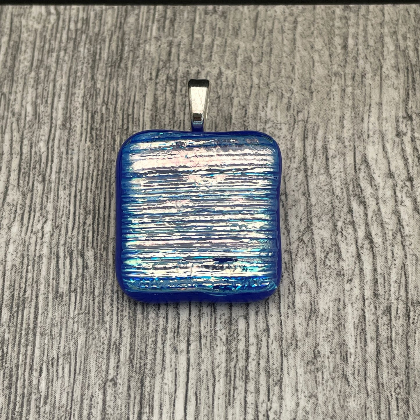 Blue, pink, gold, silver square dichroic glass pendant with leather cord.