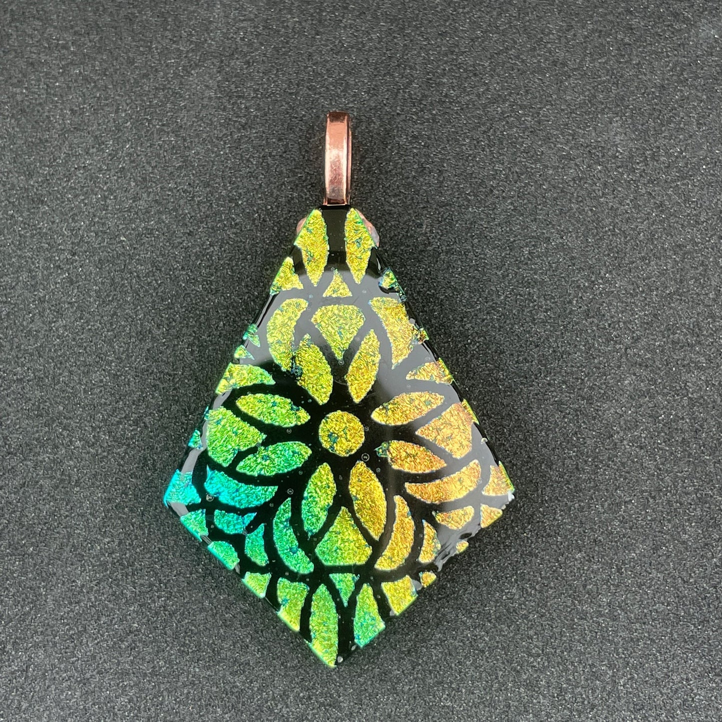 Etched peach, gold, and teal on black diamond-shaped dichroic glass pendant.