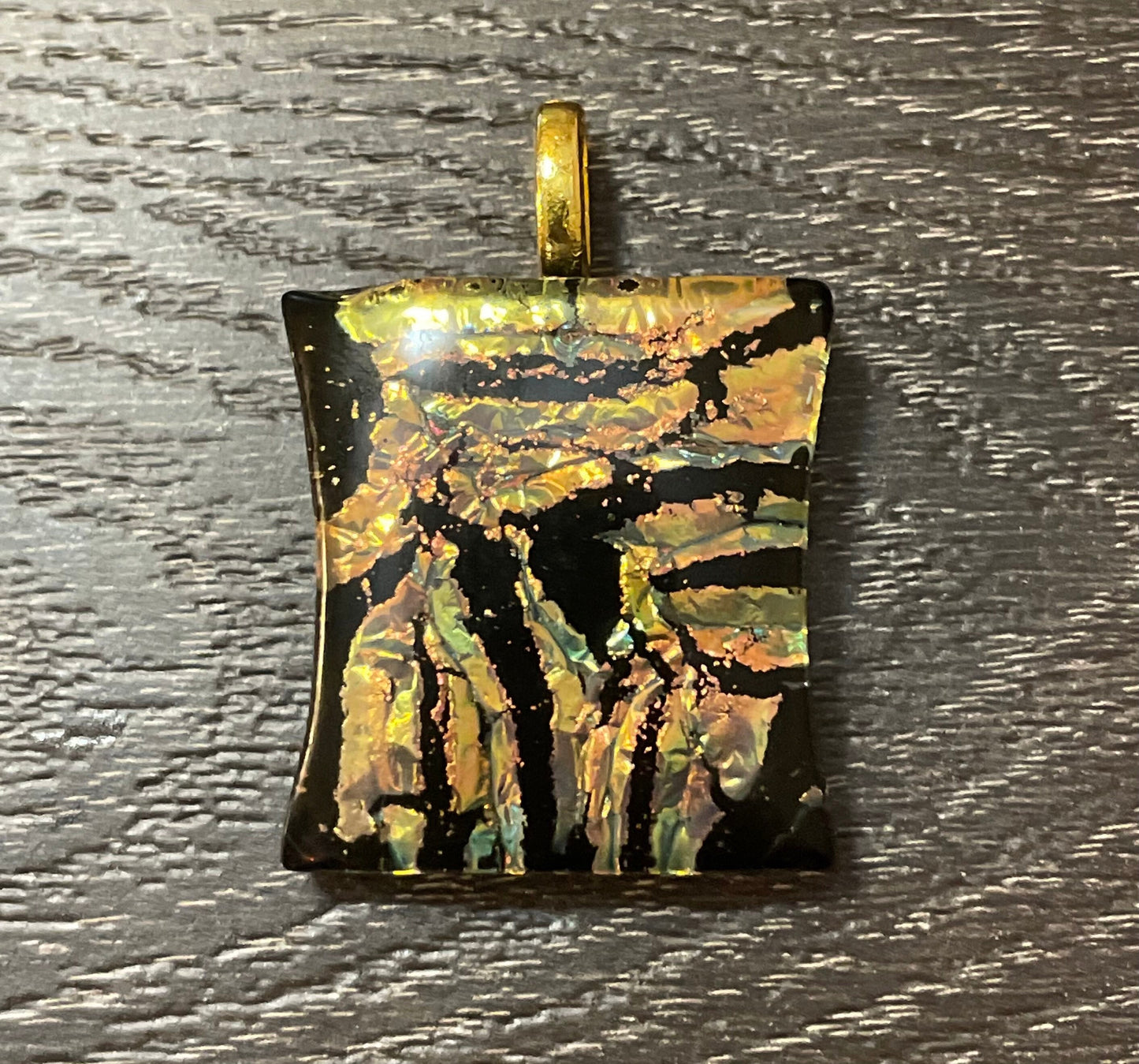 Gold, peach and hints of teal on black dichroic glass pendant with leather cord.