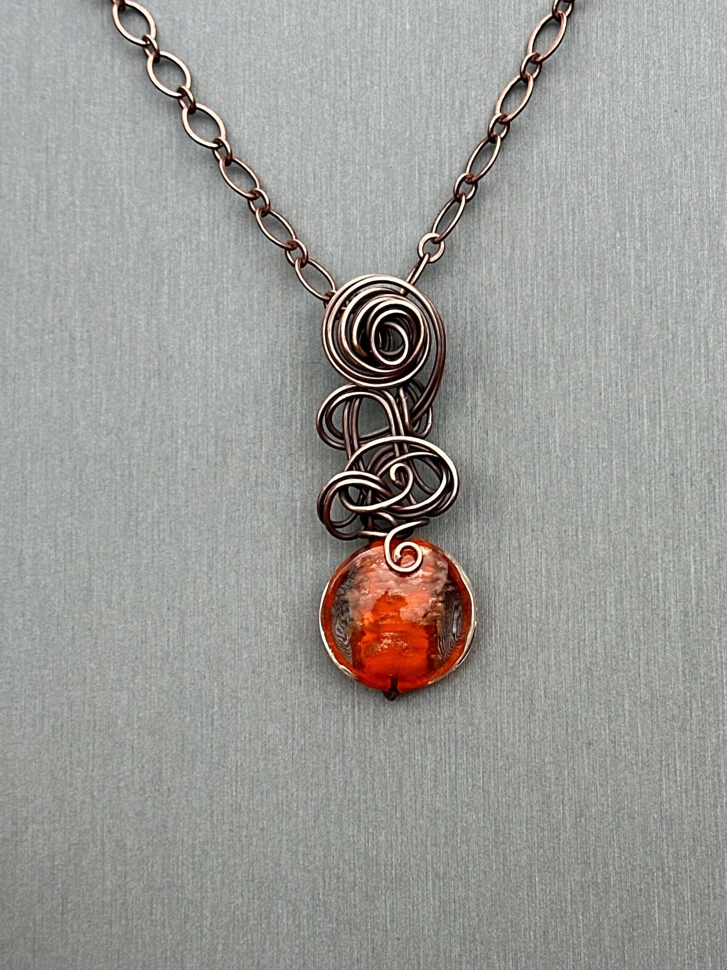 Orange glass bead with copper glitter flecks and copper freeform pendant